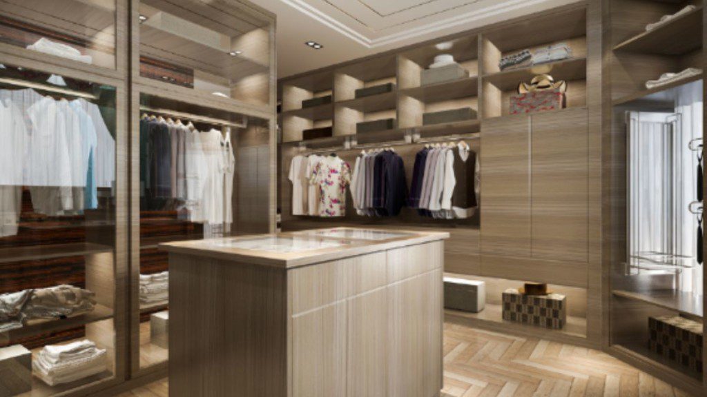 closet grande com material amadeirado e roupas claras penduradas