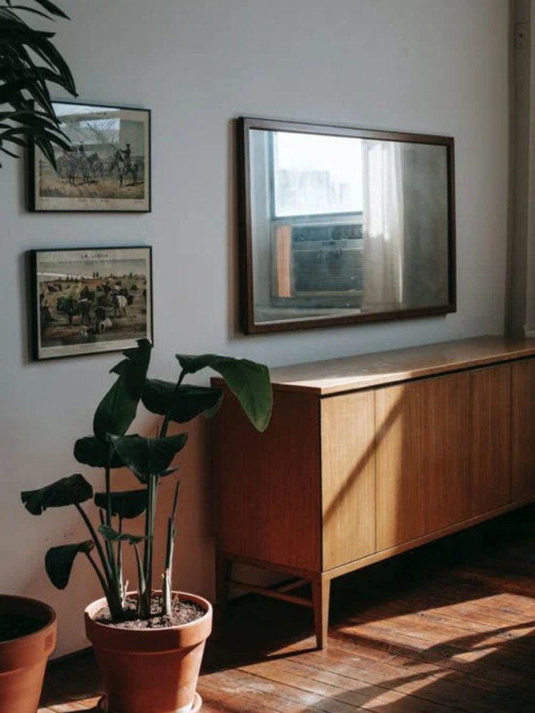 quarto rústico com cômoda de madeira e espelho retangular na parede