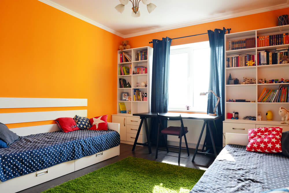 Foto de um quarto para crianças usando cores complementares laranja e azul. 