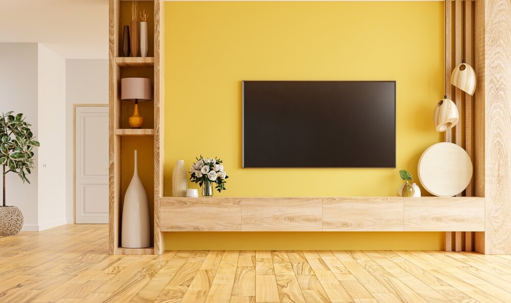 Foto de uma sala de TV em tons de amarelo. 
