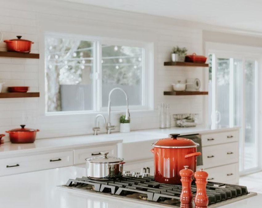 cozinha escandinava com panelas vermelhas e móveis brancos