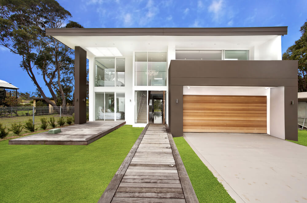 Fachada de uma casa com estilo quadrada, projetada com linhas retas. 