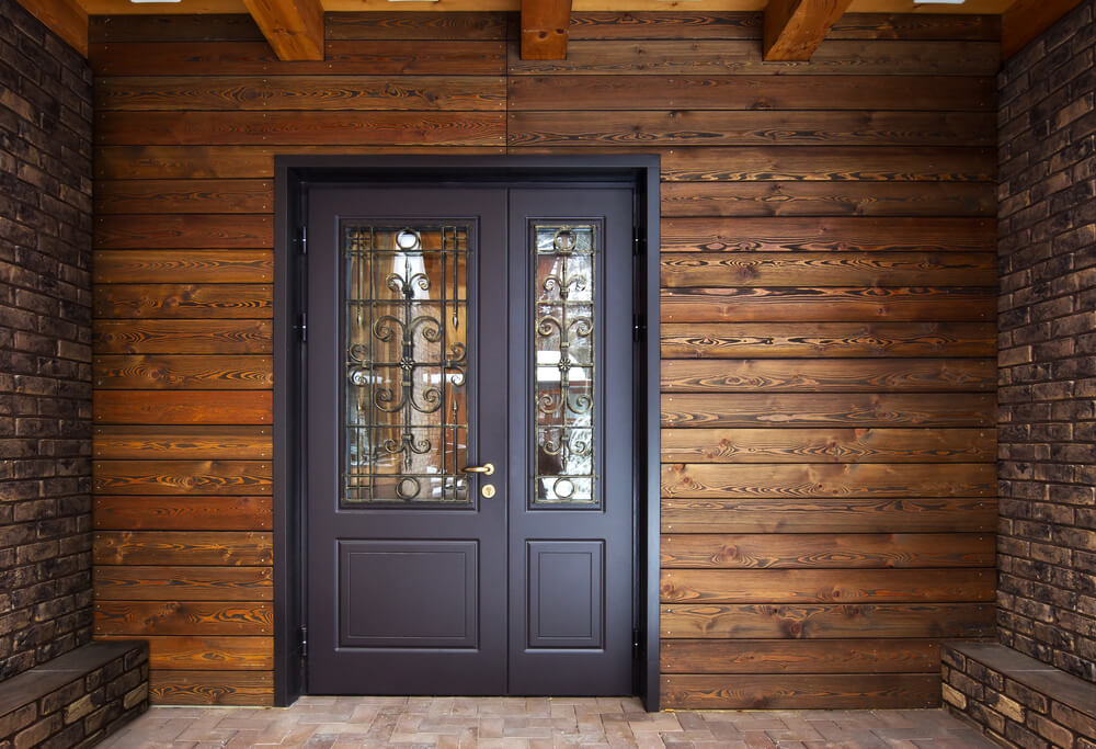 Frente de casa simples de madeira, com uma porta cinza