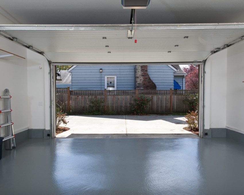 Imagem de uma garagem com piso de concreto pintado.
