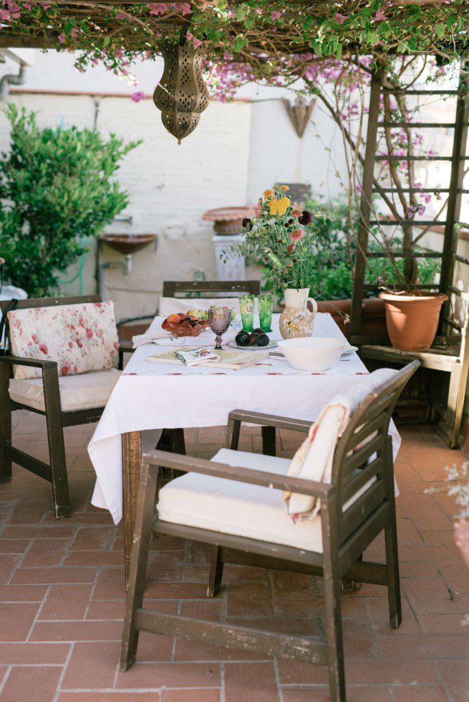 área gourmet acolhedora com cadeiras brancas acolchoadas e muitas plantas