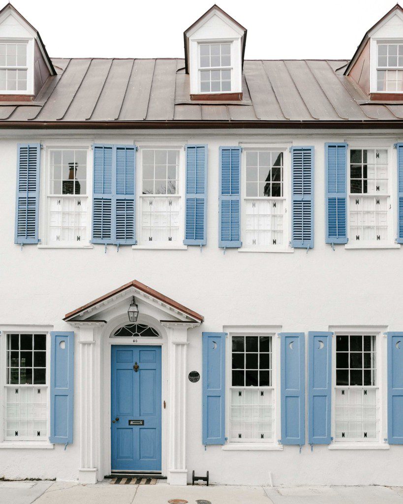 frente de casa vintage de dois andares com tons azuis e brancos
