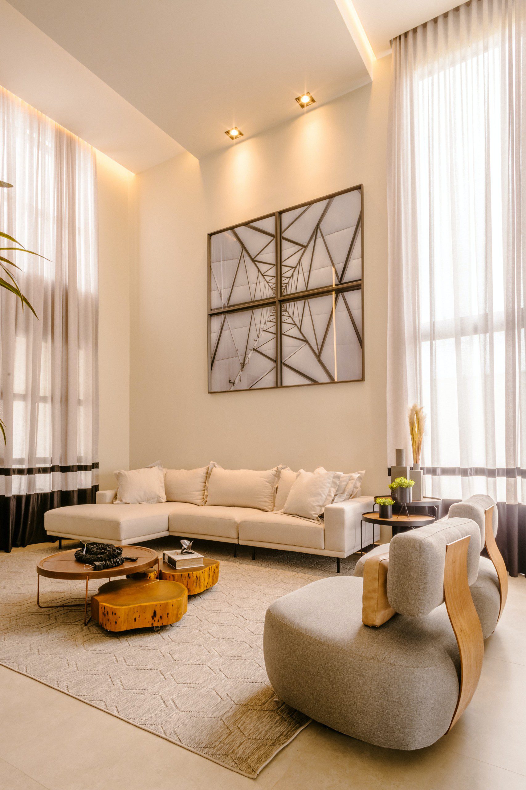 Imagem de uma sala de estar moderna e clean com sofá, tapete e luzes de destaque nos quadros.