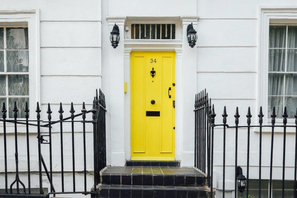 casa branca com a porta amarela