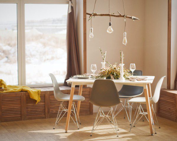 Sala de jantar rústica, com decoração de madeira e lustre pendente em tons neutros