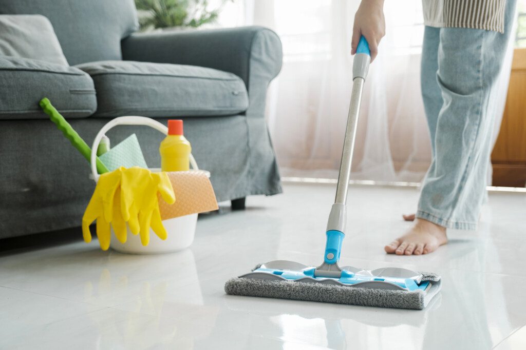 Foto que ilustra matéria sobre como limpar porcelanato mostra uma pessoa passando um pano macio no chão.