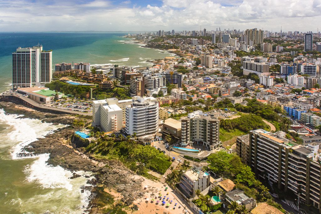  Imagem que ilustra matéria sobre o que fazer em Salvador mostra a região de Rio Vermelho na capital baiana com prédios, casas e o mar ao fundo.
