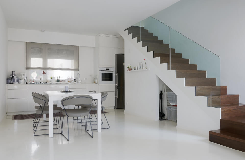 Foto que ilustra matéria sobre tipos de piso mostra uma cozinha com um piso branco brilhante, que passou por revestimento de resina de epóxi.