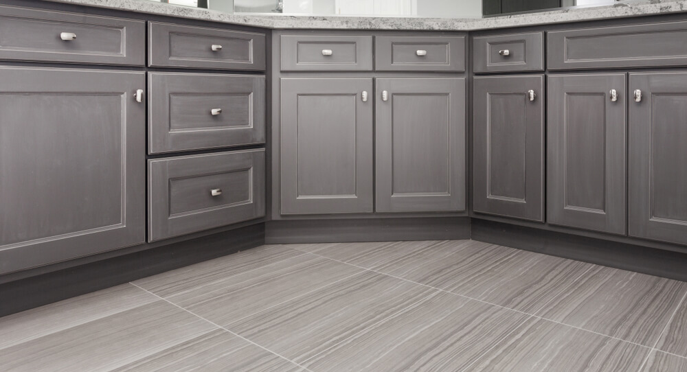 Porcelanato cinza no chão de uma cozinha, combinando com a cor dos armários embutidos.