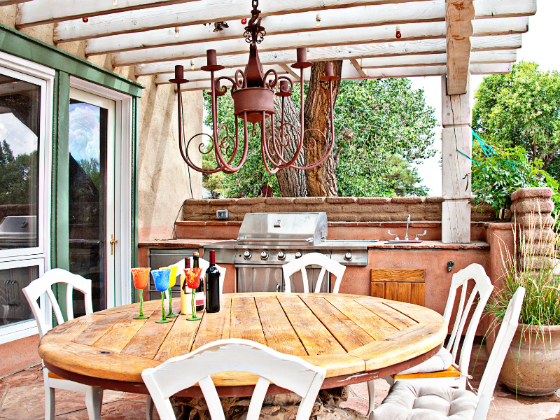 Área gourmet externa com móveis de madeira, estilo rústica. Imagem disponível em Canva.