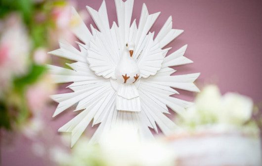 Foto que ilustra matéria sobre decoração para batizado mostra uma imagem do Divino Espírito Santo, representado por uma pomba branca.