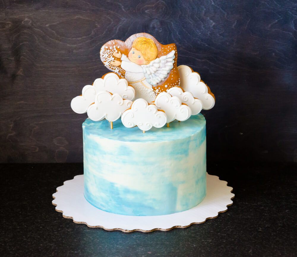 O tom azul do bolo ganha um toque ainda mais angelical com o topo de nuvens e anjinho