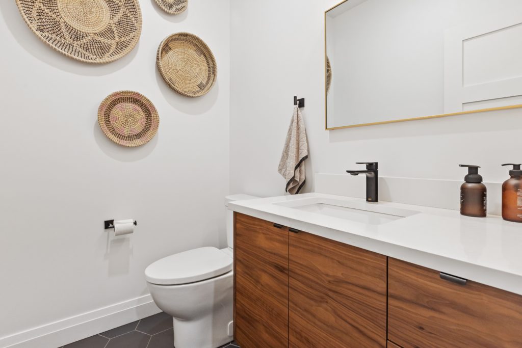 lavabo branco com armário de madeira debaixo da pia. Imagem disponível em Unsplash.