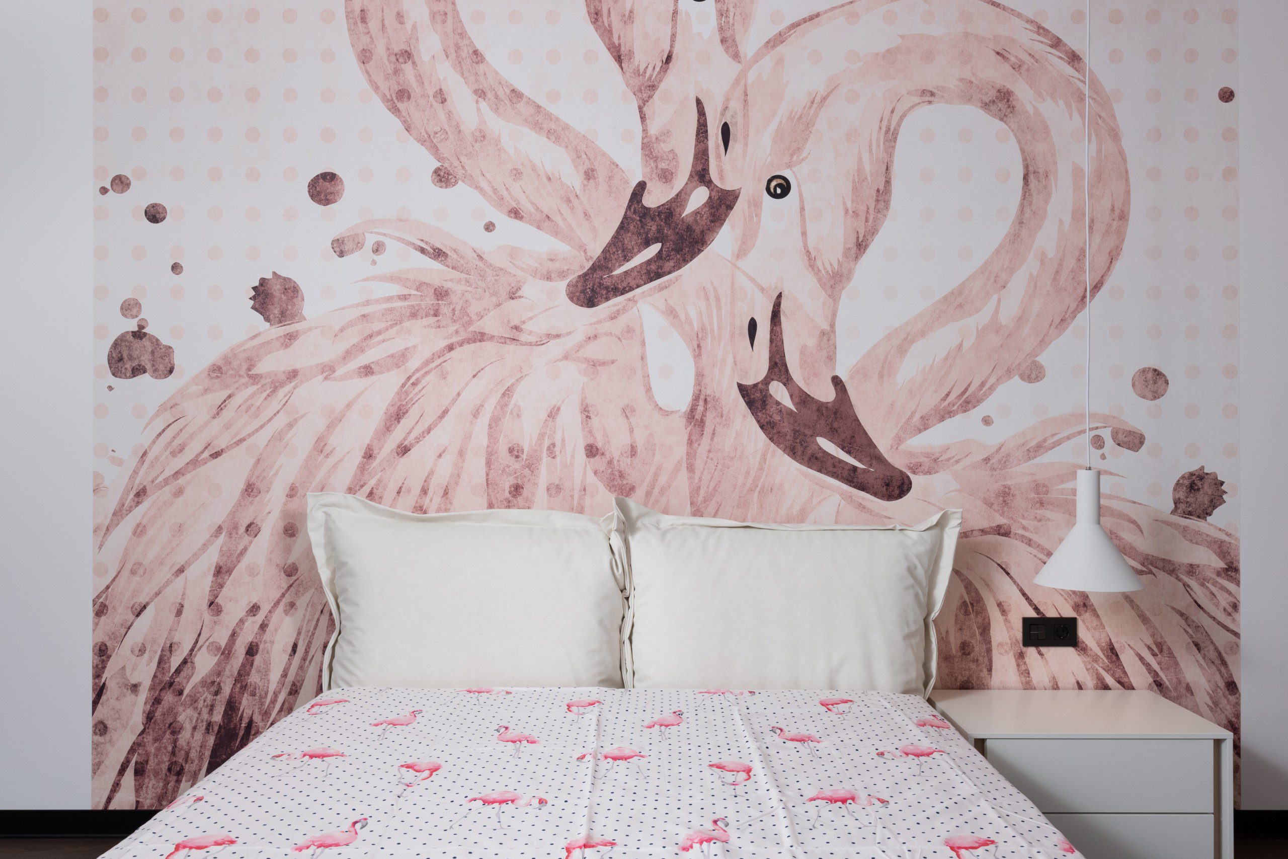 Imagem de um quarto com uma cabeceira feita de papel de parede com flamingos. 