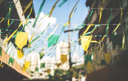 Decoração de rua com bandeirinhas em verde e amarelo para assistir aos jogos do Brasil.
