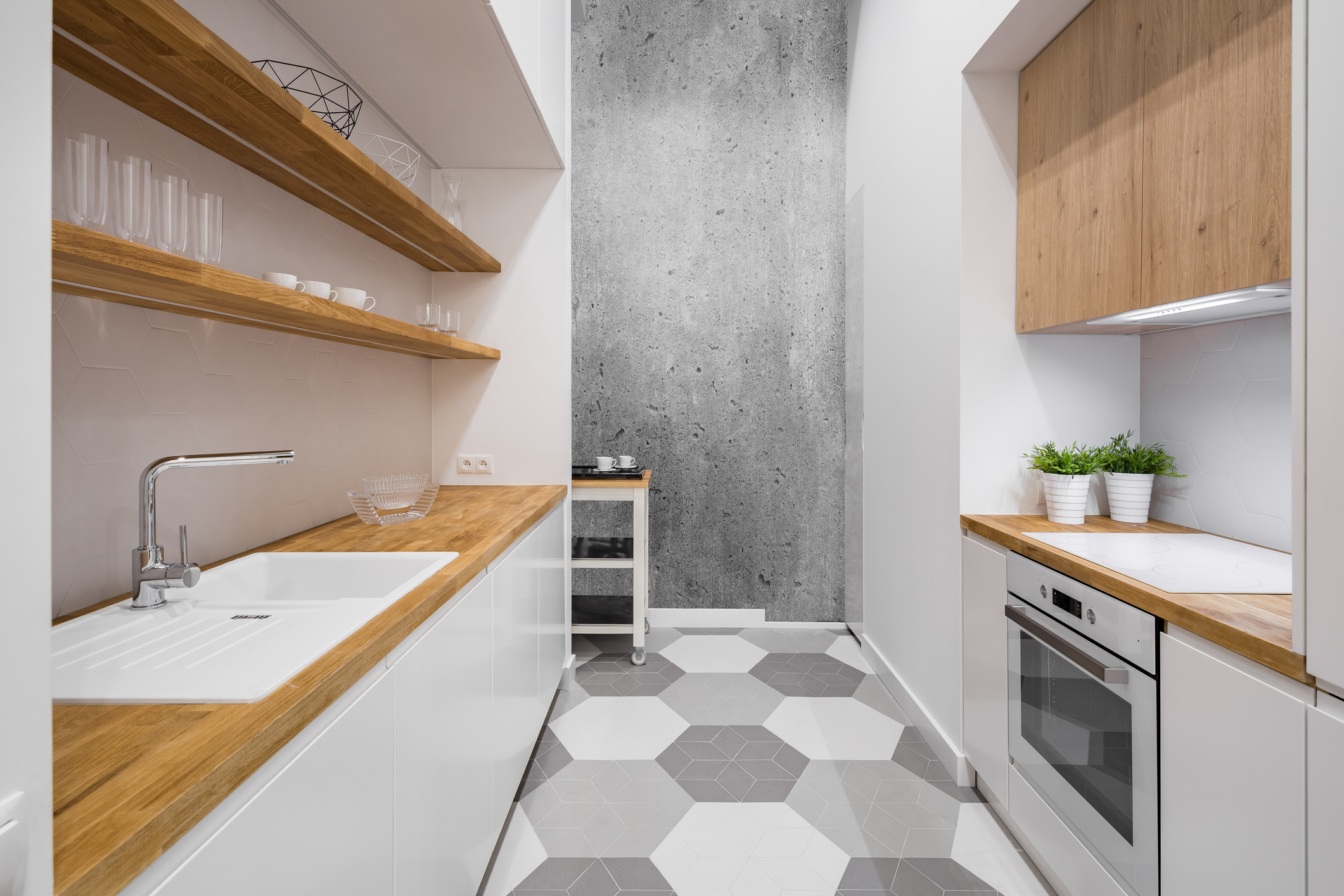 Imagem de uma cozinha branca com prateleiras, bancadas e portas de armários em madeira.