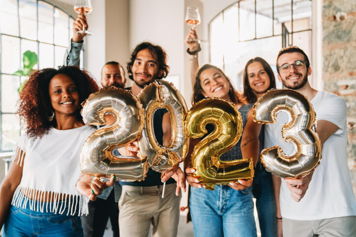 Foto que ilustra matéria sobre decoração de ano novo mostra um grupo de jovens segurando balões com o número 2023, para representar a virada de um ano para outro.