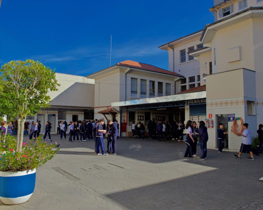 Foto que ilustra matéria sobre escolas particulares em Mogi das Cruzes mostra o pátio do Instituto Dona Placidina repleto de alunos em um dia de céu azul.