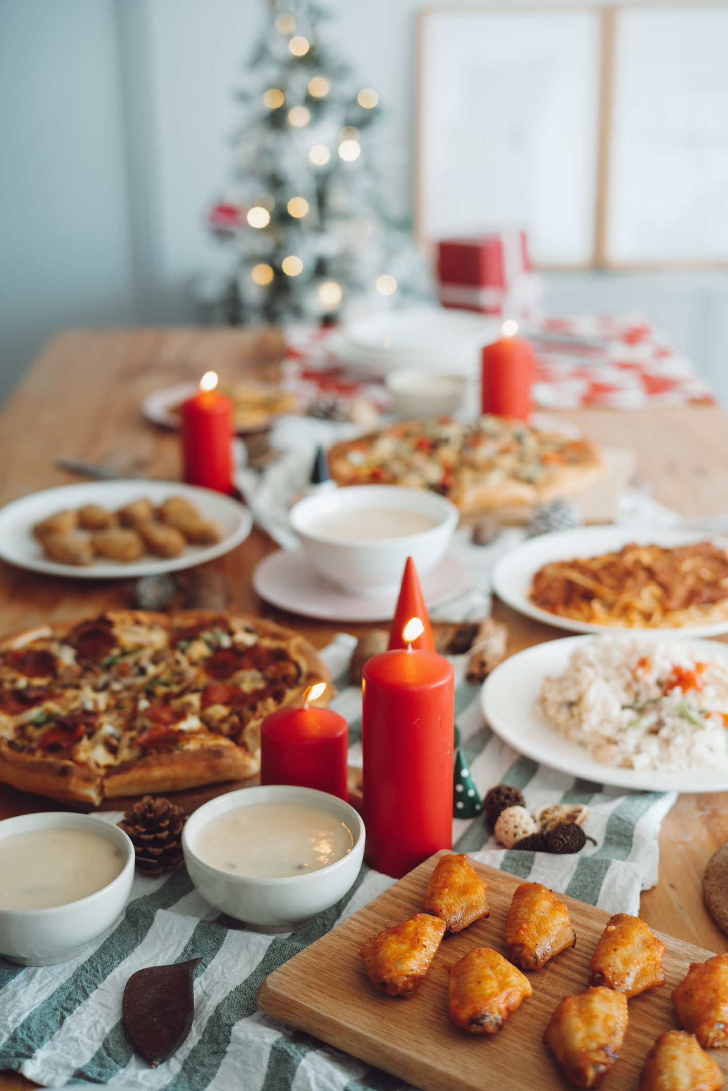 Mesa de Natal com pratos branco e velas vermelhas.