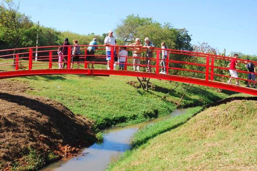 Foto que ilustra matéria sobre Parques em Hortolândia mostra uma pequena ponte vermelha sobre um córrego no Parque Chico Mendes