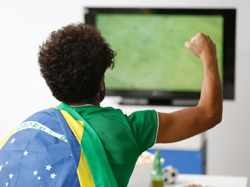 Torcedor do Brasil vibra em frente ao aparelho de televisão.