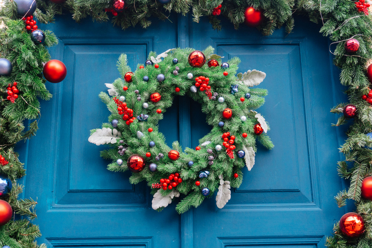 Guirlanda de Natal em uma porta de entrada azul.