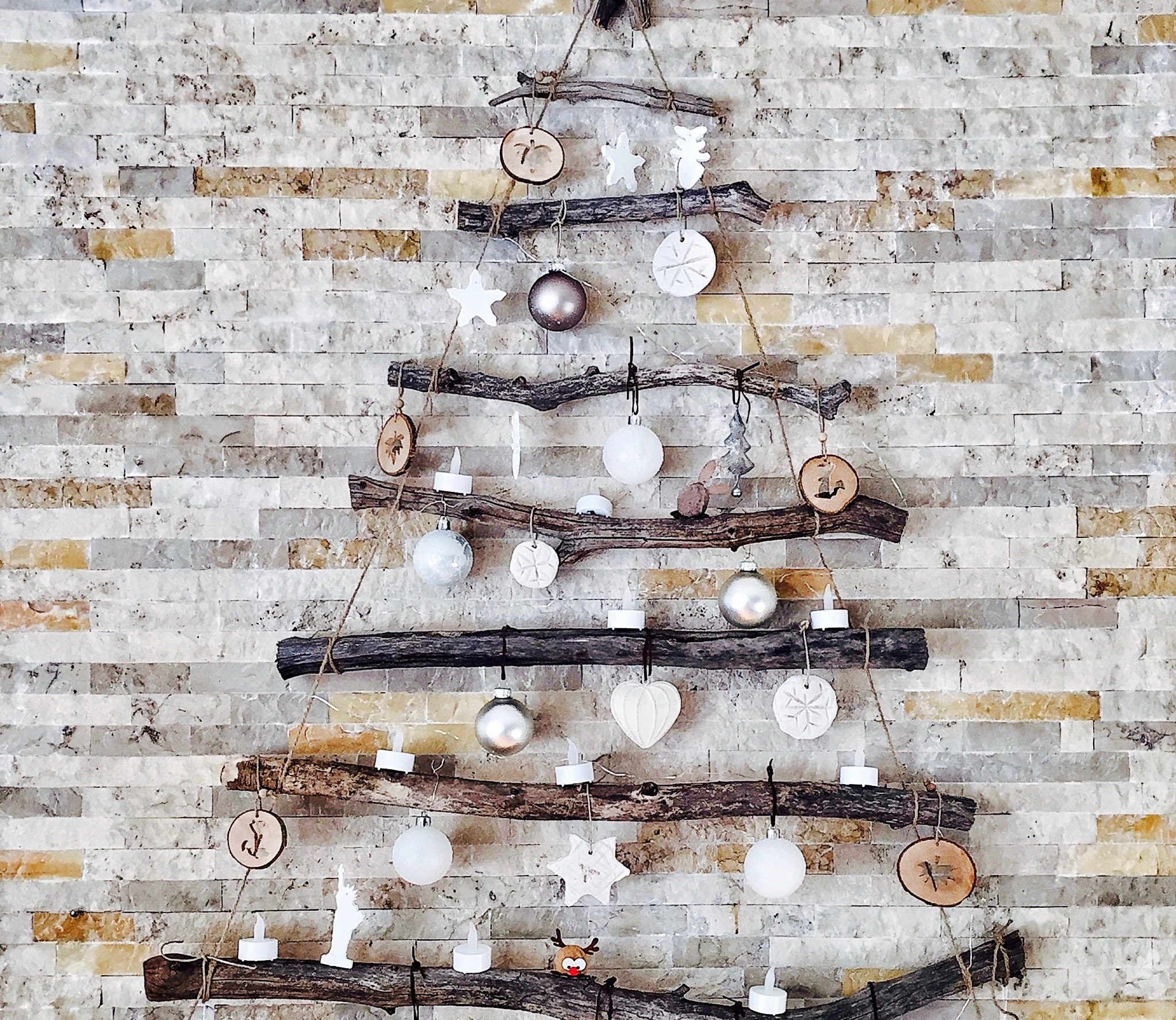 Galhos secos e enfeites natalinos em branco e prata podem trazer um charme a mais para a sua árvore de Natal. 