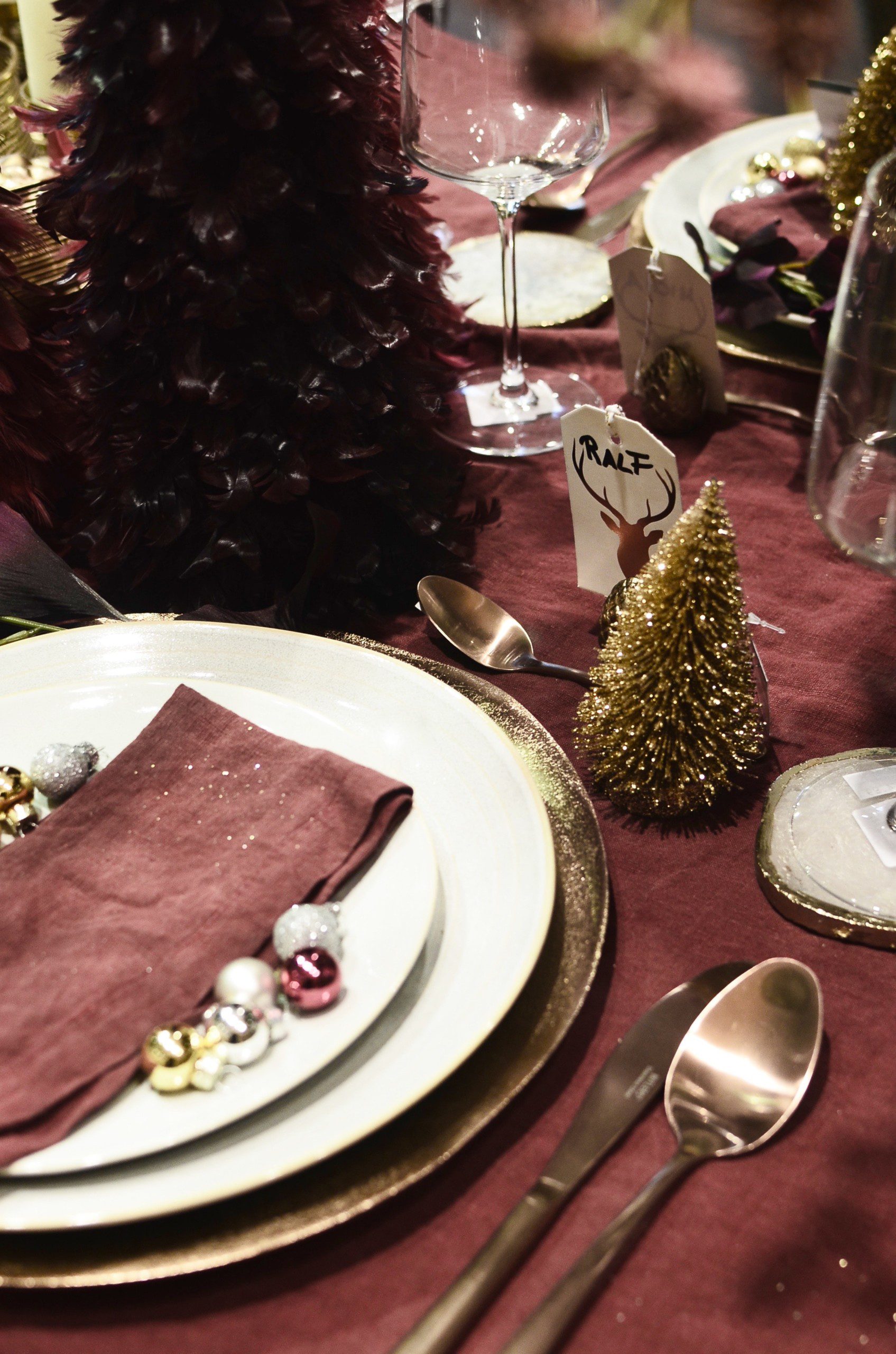 Mesa de Natal em tom vinho, mini árvore e enfeites decorativos pela mesa.