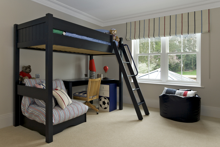 Imagem de um quarto infantil com cama suspensa e mesa de estudos embaixo.