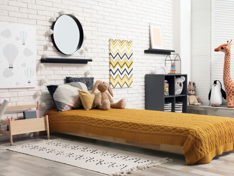 Quarto montessoriano com quadro decorativos, cama e móveis rebaixados. Imagem disponível em Canva.