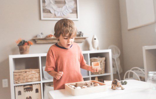 Criança se divertindo em seu quarto montessoriano. Imagem disponível em Canva.