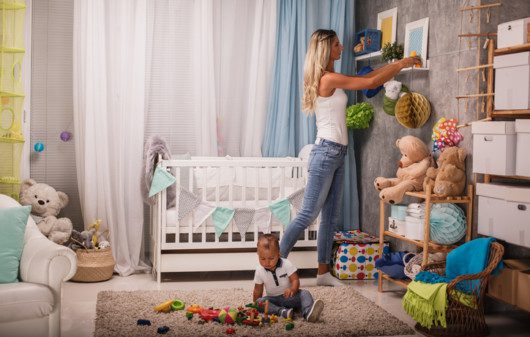 Imagem de uma mãe organizando o quarto do filho.