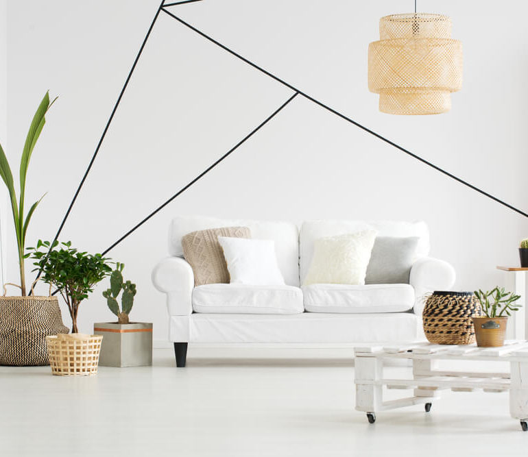 Sala de estar de estilo escandinavo aposta em pintura setorizada apenas com traços formando figuras geométricas.