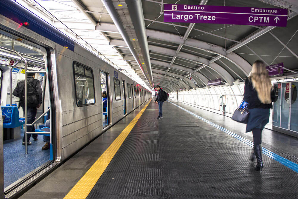 Foto que ilustra matéria sobre o Terminal Santo Amaro mostra a plataforma de metrô da Estação Santo Amaro com um trem de portas abertas à esquerda aguardando a entrada de passageiros.