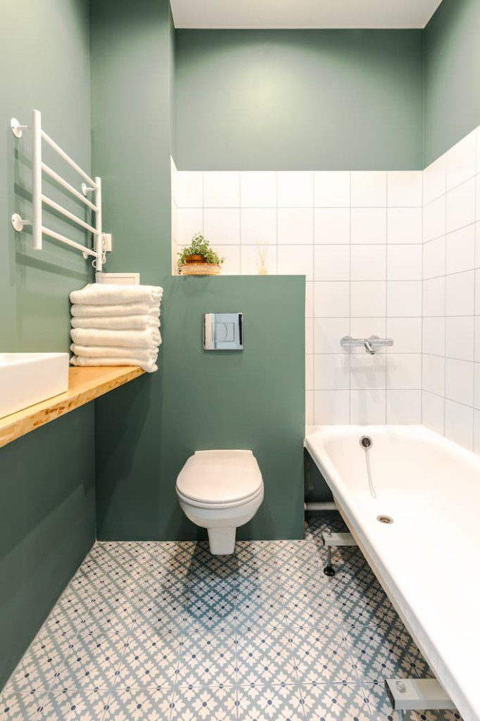 Banheiro retrô verde, com detalhes em branco. Imagem disponível em Getty Images.