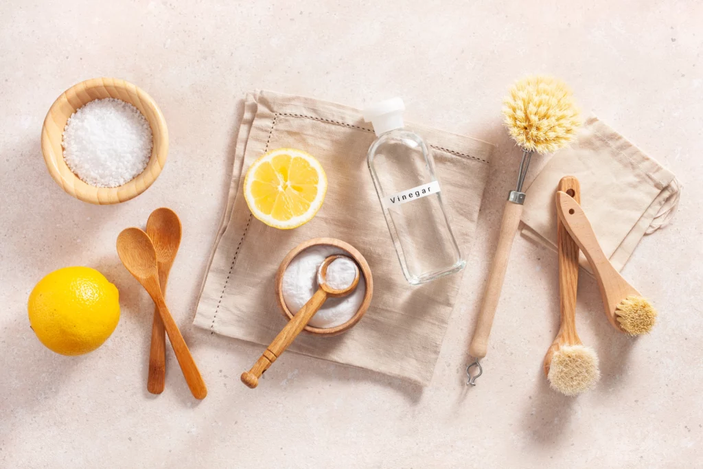  Imagem de alguns produtos em cima de uma bancada, como limão, vinagre, bicarbonato de sódio e escovas de higiene para ilustrar matéria sobre como clarear roupa branca com limão