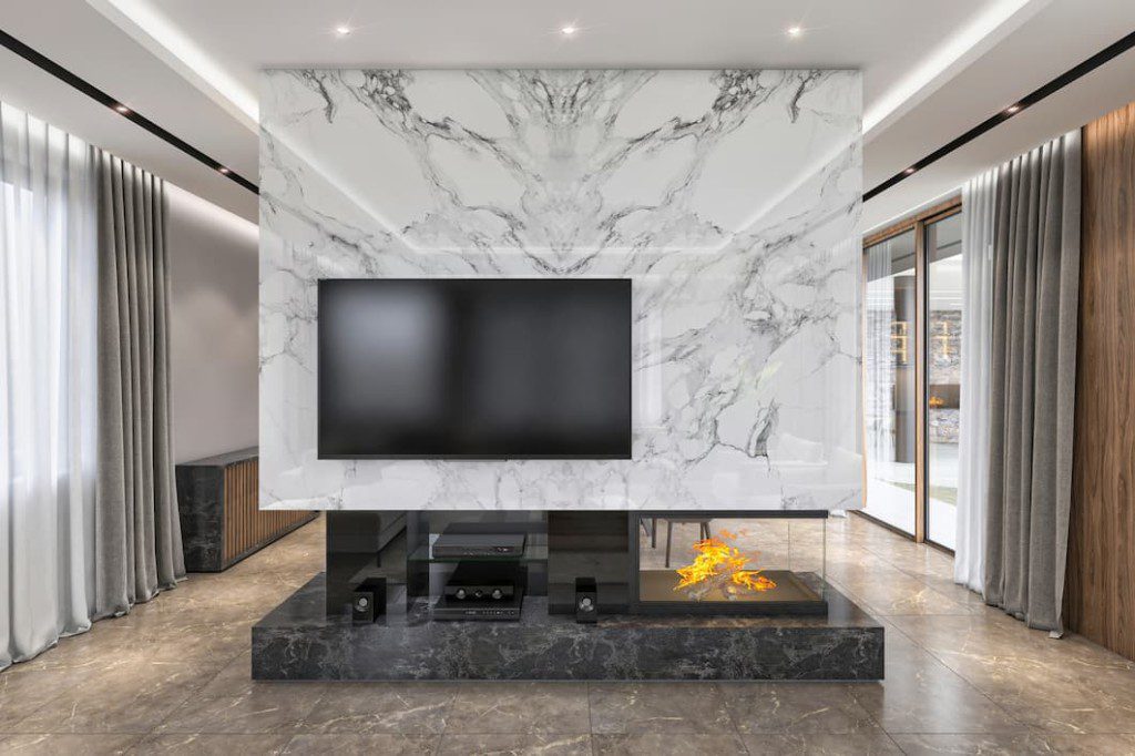 Sala de tv com painel de mármore. Imagem disponível em Getty Images.
