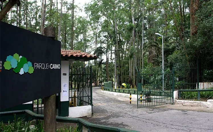 Imagem da entrada do Parque do Carmo, em São Paulo, mostra portão de entrada e vegetação no início do caminho para ilustrar matéria sobre melhores parques gratuitos em SP