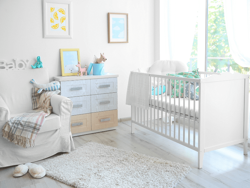 Quarto de bebê minimalista com brinquedos e objetos de decoração em tons claros.