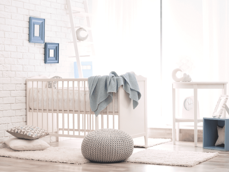 Quarto de bebê com móveis de madeira em cor branca e decoração minimalista.