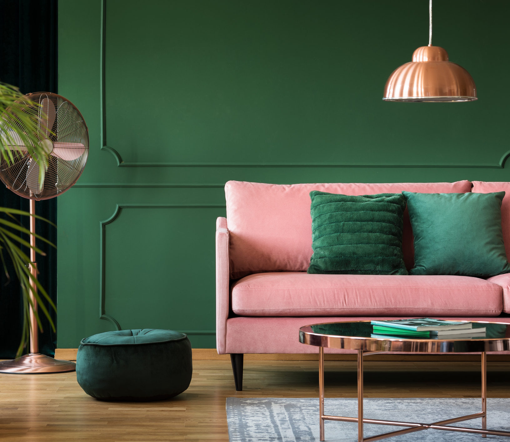 Decoração verde combinando com um sofá rosa e detalhes em rose gold.