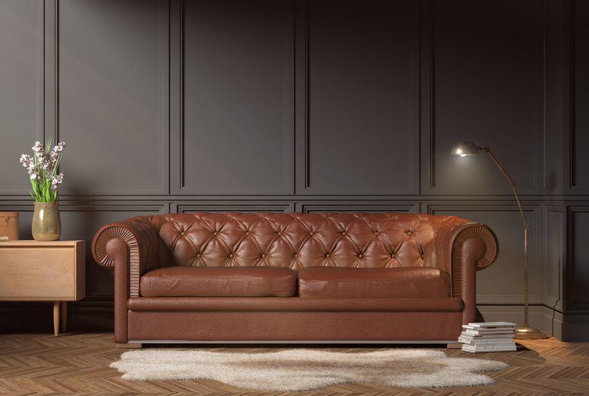 Foto que ilustra matéria sobre a técnica capitonê de estofamento mostra um sofá de couro marrom.
