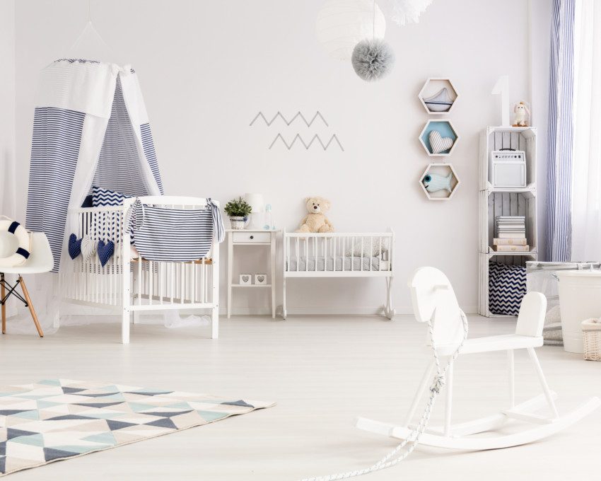 Quarto de bebê clean, todo em branco e detalhes em azul, com móveis funcionais.