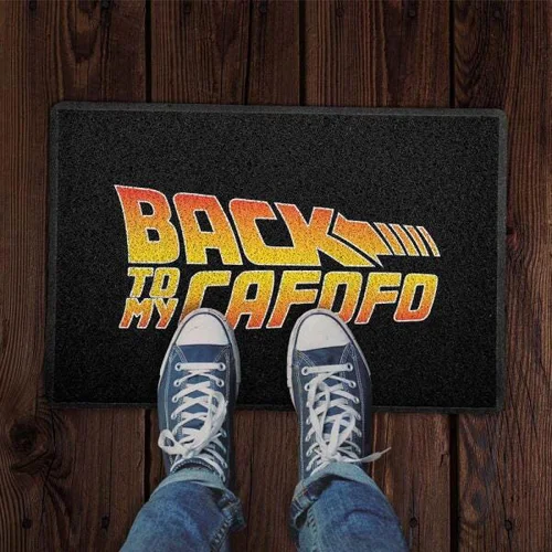A imagem mostra um capacho escrito "back to my cafofo", remetendo ao filme "de volta para o futuro". Tem na foto também um par de pés com tênis all star. 