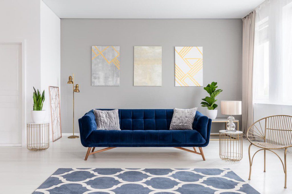Elegante sofá azul marinho, no meio de uma sala de estar.