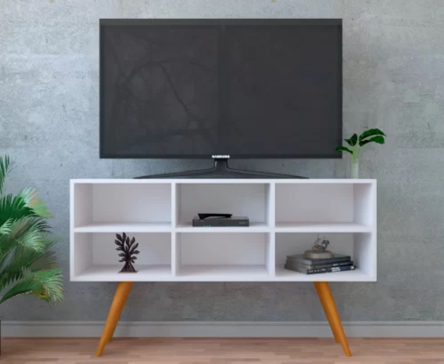 Foto que ilustra matéria sobre quanto custa mobiliar um apartamento mostra um rack branco com pernas em cor de madeira clara com uma TV em cima